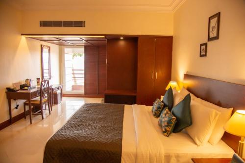 1 dormitorio con cama, mesa y escritorio en Naveen Residency en Amargol