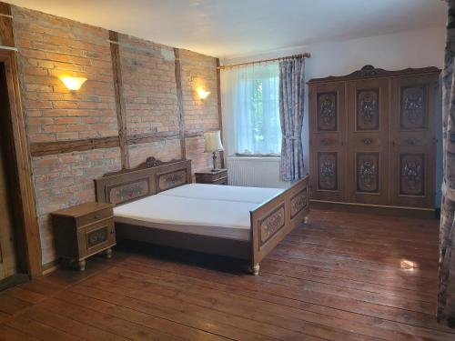 1 dormitorio con cama y pared de ladrillo en Pałac Heymanna - Oficyna, en Ścibórz