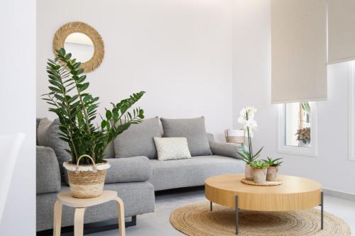 a living room with a couch and a table with plants at KORINA APART HOTEL KAVOS in Kavos