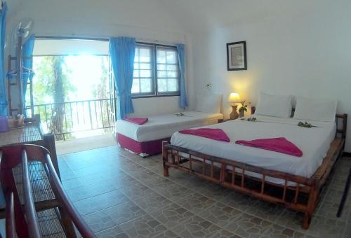 a bedroom with two beds and a balcony at Poseidon Bungalows in Khao Lak