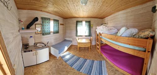 a small bedroom with a bunk bed in a tiny house at Bungalåven Cottages & Rooms in Børselv