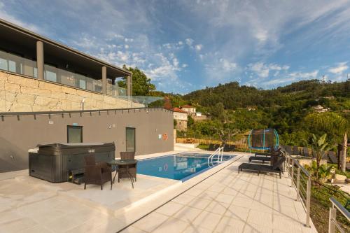 a house with a swimming pool and a patio at Quinta Flor de Lis, Gerês in Vieira do Minho