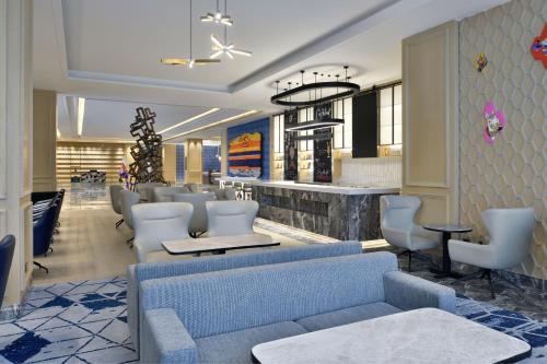 a lobby with a waiting room with chairs and a bar at Le Meridien Amritsar in Amritsar