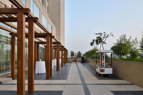 a hallway of a building with a table and a golf cart at Le Meridien Amritsar in Amritsar