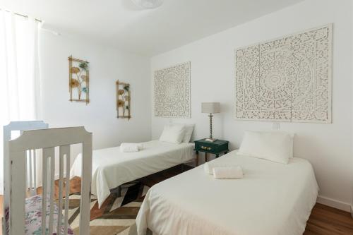 two beds in a room with white walls at Quinta Flor de Lis, Gerês in Vieira do Minho