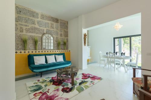 a living room with a blue couch and a table at Quinta Flor de Lis, Gerês in Vieira do Minho