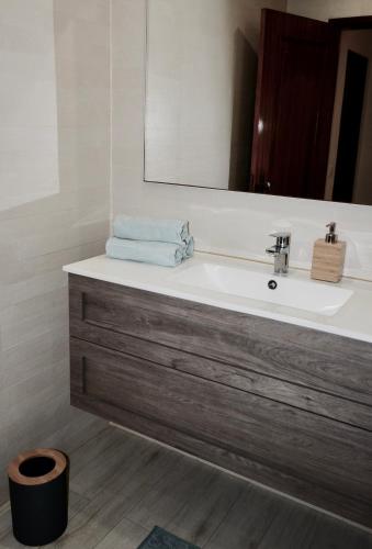 a bathroom with a sink and a mirror at Caparica Coast Townhouse Apartments in Charneca