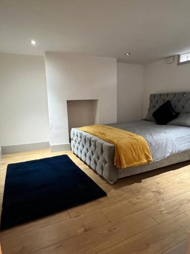 a bedroom with a large bed and a blue rug at Ground Floor Two Bed Cairo Street in Warrington
