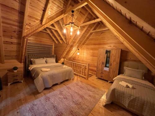 Zambula bungalov في طرابزون: غرفة نوم بسريرين في كابينة خشب
