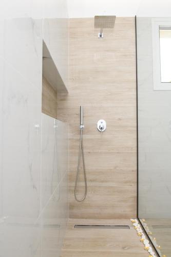 a shower in a bathroom with a glass door at KORINA APART HOTEL KAVOS in Kavos