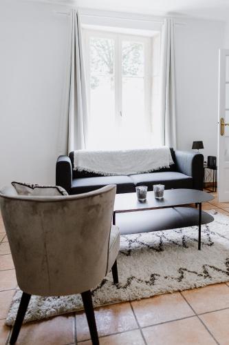 un salon avec un canapé, une table et une chaise dans l'établissement Maison Madeleine, à La Flèche