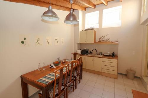 een keuken met een lange houten tafel en stoelen bij MONAHOUR in Heraklion