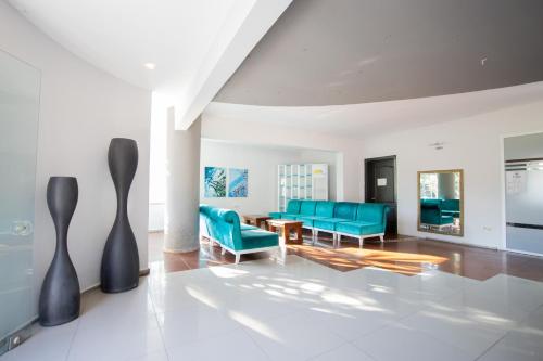 a living room with blue chairs and a table at PİGALE BEACH RESORT in Kuşadası