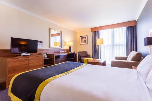 a hotel room with a large bed and a television at Holiday Inn Newcastle Gosforth Park by IHG in Newcastle upon Tyne