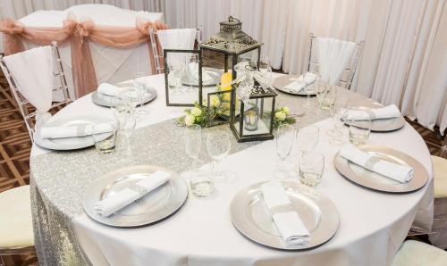 a white table with plates and glasses on it at Holiday Inn Newcastle Gosforth Park by IHG in Newcastle upon Tyne