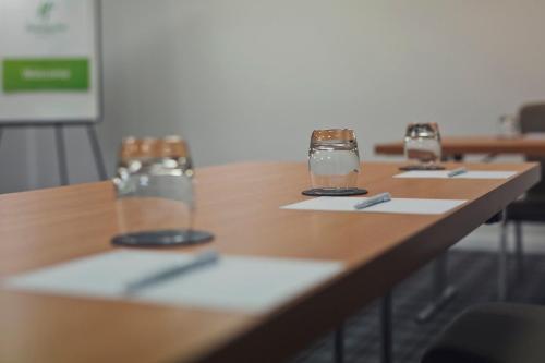 a row of tables with glasses and utensils on them at Holiday Inn Newcastle Gosforth Park, an IHG Hotel in Newcastle upon Tyne