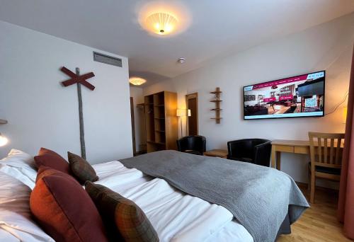 a bedroom with a bed and a tv on the wall at Hotell Funäsdalen in Funäsdalen