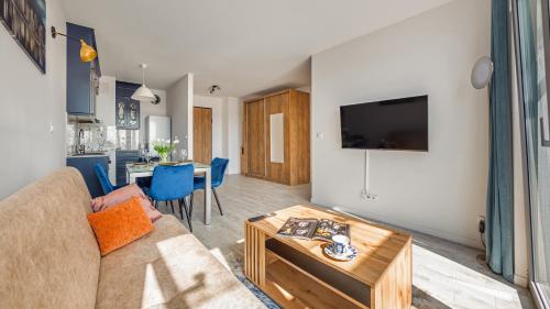 a living room with a couch and a table at Plac Unii, Sun & Snow in Gdynia