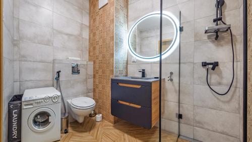 a bathroom with a washing machine and a sink at Plac Unii, Sun & Snow in Gdynia
