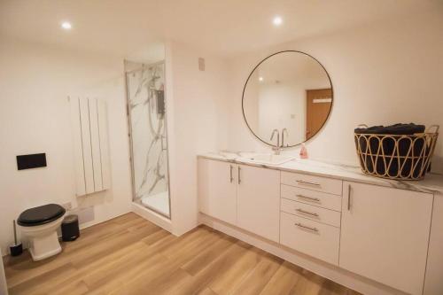 une salle de bain avec un lavabo et un miroir dans l'établissement The Beach Box By Air Premier, à Seaford