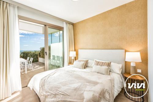 ミハス・コスタにあるViVi Homes - Blue View Pool, Sauna, Gym & Sea Viewの大きなベッドとバルコニーのある寝室
