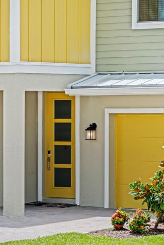 a yellow garage door on a house at Magical Themed Home - Disney 15 min in Kissimmee