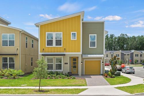 a yellow house with a garage in a residential neighborhood at Magical Themed Home - Disney 15 min in Kissimmee