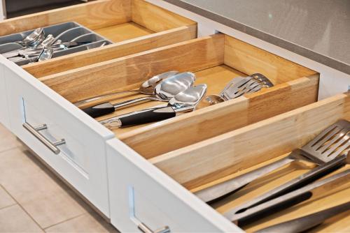 a kitchen with wooden drawers filled with utensils at Magical Themed Home - Disney 15 min in Kissimmee