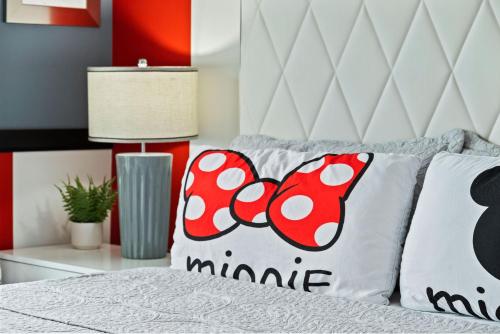 a bedroom with a bed with a mickey mouse pillow at Magical Themed Home - Disney 15 min in Kissimmee