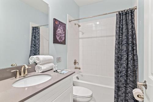a bathroom with a sink and a toilet and a tub at Magical Themed Home - Disney 15 min in Kissimmee