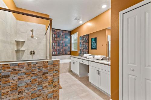 a bathroom with a walk in shower and a sink at Magical Themed Home - Disney 15 min in Kissimmee