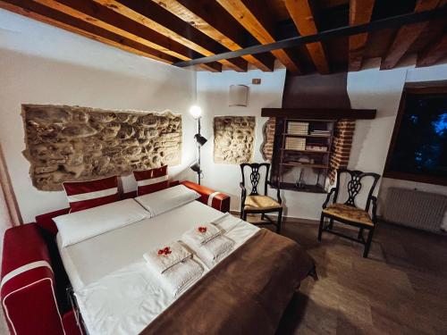 a bedroom with a bed and two chairs and a fireplace at Relais nel Castello in Bassano del Grappa