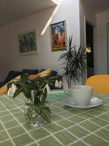 a table with a vase and a cup on a table at Lovely guest house close to the sea and forest! in Domsten