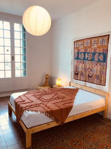 une chambre avec un grand lit et un lustre dans l'établissement VILLA TAPÔA - Maison au coeur de Marseillan, à Marseillan