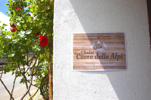 a sign on the side of a building with a plant at Chalet Cuore delle Alpi in Airolo