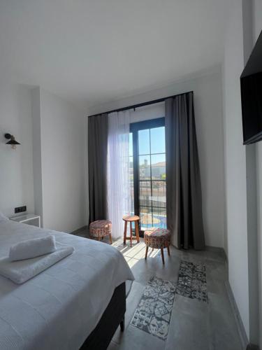 a bedroom with a bed and a large window at La Chance Otel Alaçatı in Alacati