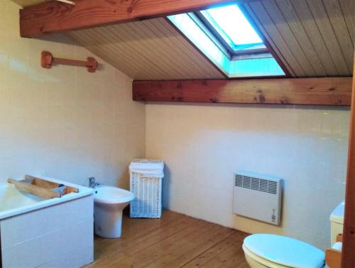 La salle de bains est pourvue de toilettes, d'un lavabo et d'une lucarne. dans l'établissement Casa con piscina en Santa Leocadia, à Sainte-Léocadie