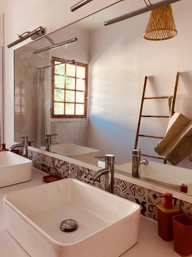 une salle de bain avec un lavabo blanc et un miroir dans l'établissement VILLA TAPÔA - Maison au coeur de Marseillan, à Marseillan