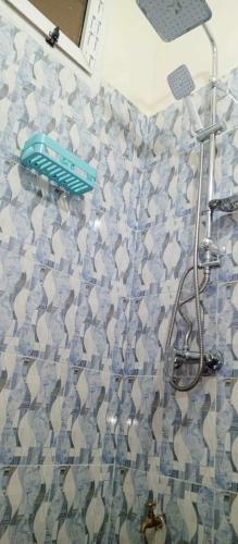 um chuveiro na casa de banho com piso em azulejo em RÈSIDENCE NGUARY em Dakar