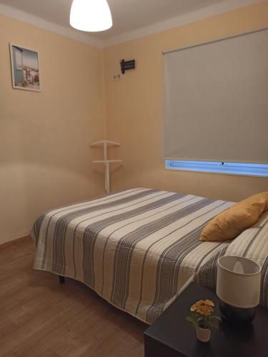 - une chambre avec un lit et une croix sur le mur dans l'établissement Apartamento El Pórtico de Muros, à Muros de Nalón