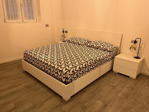 a bedroom with a bed with a black and white comforter at Emma House in Bellano