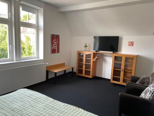 a room with a bed and a tv and a couch at HARZ HOTEL und Gästehaus am Bornweg in Bad Sachsa