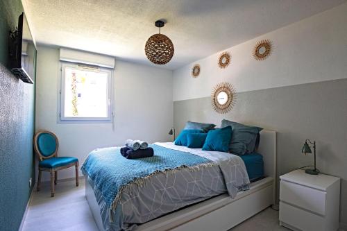 ein Schlafzimmer mit einem blauen Bett und einem Stuhl in der Unterkunft Le Palmier Vert - Magnifique T2 à Montpellier- Balcon 16m2 - CLIM -WIFI in Montpellier