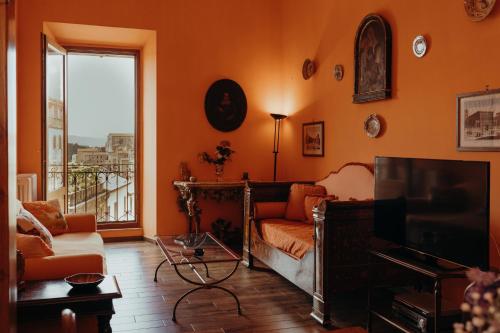 ein Wohnzimmer mit einem Sofa und einem TV in der Unterkunft Casa Caracciolo in Pitigliano