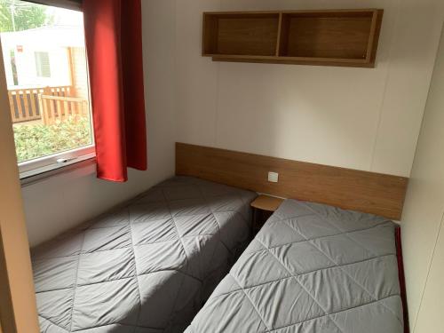 een kleine kamer met een bed en een raam bij les sables du midi in Valras-Plage