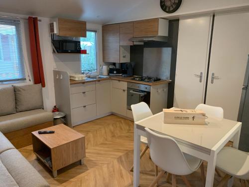 une cuisine et un salon avec une table et des chaises dans l'établissement les sables du midi, à Valras-Plage