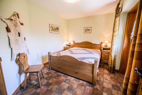 a bedroom with a wooden bed and a chair at ECO Tourist Farm Kostanje in Sevnica