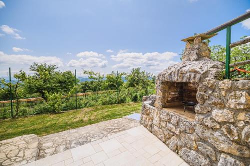 an outdoor stone fireplace in a yard at ECO Tourist Farm Kostanje in Sevnica