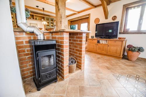 a brick fireplace in a living room with a tv at ECO Tourist Farm Kostanje in Sevnica
