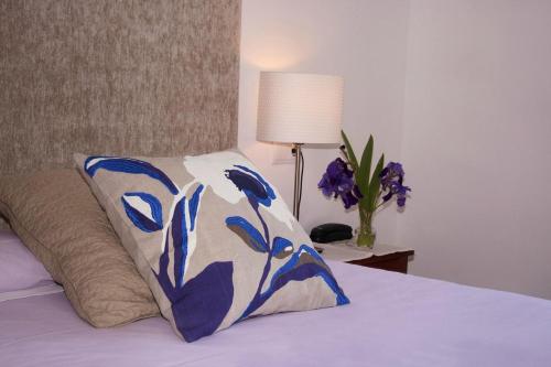 Dormitorio con cama con almohada y lámpara en badain en La Fortunada